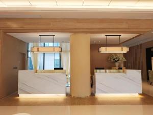 a lobby with a column and two chandeliers at Jinjiang Inn Select Xiamen International Airport in Xiamen