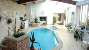 a large swimming pool in a patio with tables and chairs at Le relais de la cure in Saint-Juire-Champgillon