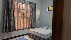 una finestra in una stanza con un letto accanto di Dans place a Moshi