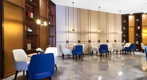 una sala da pranzo con tavoli e sedie blu e bianche di E-Cheng Hotel Yangjiang Baili Plaza a Yangjiang