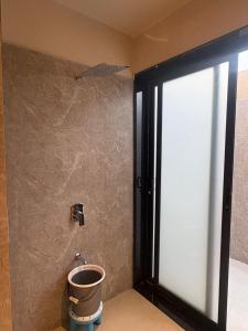 um banheiro com um balde no canto de uma parede em The Bhagwati Cottage & Villa em Ābu Road