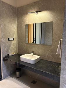 um banheiro com uma pia e um espelho em The Bhagwati Cottage & Villa em Ābu Road