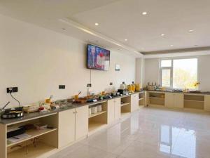 una grande cucina con TV a parete di GEM Hotel Zibo Economic Development Zone Zibo Vocational Institute a Jinan