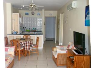 een keuken en een woonkamer met een tafel en een bank bij The Paphos Pafia 2 Apartment in Paphos City