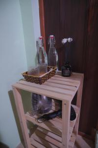 a cat sitting under a table with bottles on it at San's House in Hữu Lũng