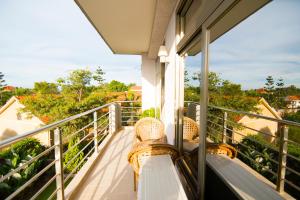 a balcony with wicker chairs and a view of trees at Naguru ViewPointe Apartments in Kampala