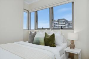 En eller flere senge i et værelse på Central Burwood 2BR Apt Steps to Train Station