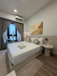 a bedroom with a large white bed and a table at Agile Residence Bukit Bintang by Luma in Kuala Lumpur