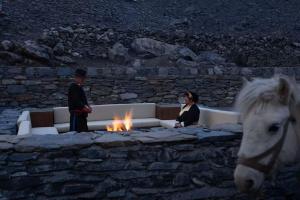 a man and a woman sitting on a couch next to a fire at Siguniang Mountain Snow Inn in Mount Siguniang