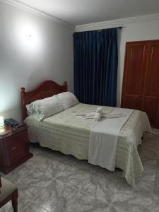a bedroom with a bed and a blue curtain at Hotel Coosonav Cartagena in Cartagena de Indias