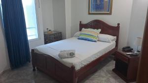 a bedroom with a bed with a pillow and a window at Hotel Coosonav Cartagena in Cartagena de Indias