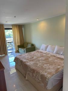 Costa bella Marina e resort في انغرا دوس ريس: غرفة نوم بها سرير وأريكة وكرسي