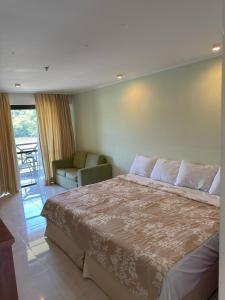 Costa bella Marina e resort في انغرا دوس ريس: غرفة نوم بها سرير كبير وكرسي