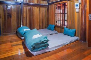 two beds in a boat with blue pillows at San's House in Hữu Lũng
