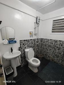 un baño con inodoro y lavabo en Joaquinn's Bed and Breakfast, en El Nido