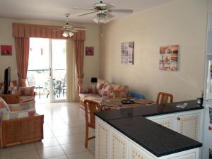 een keuken en een woonkamer met een bank en een tafel bij The Paphos Pafia 2 Apartment in Paphos City
