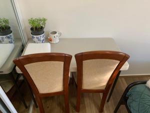 Mount Kuring-GaiAmazing Stunning Garden View King Bedroom with shared bathroom at MC 2079的一张带两把椅子的白色桌子和两株植物 更多5张照片