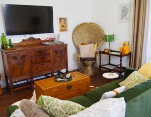 a living room with a couch and a tv on a wall at Smithtown Champagne Bed and Bubbles in Smithtown