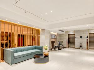 a living room with a blue couch and a table at City Comfort Inn Tangshan Railway Station Lunan District Government in Tangshan