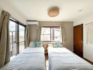 two beds in a room with a window at #43 Sajima nagi in Yokosuka