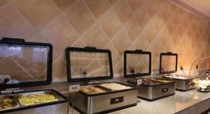 通辽Vienna Hotel Inner Mongolia Tongliao Development Zone的柜台上摆放着几个装有食物的托盘。