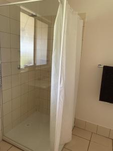 a shower with a glass door in a bathroom at The Vale Farmhouse Rural Setting in Farrell Flat