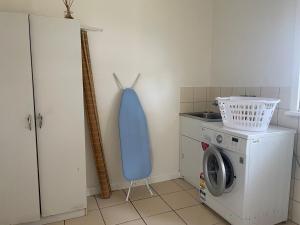 a kitchen with a blue object on the wall next to a washing machine at The Vale Farmhouse Rural Setting in Farrell Flat