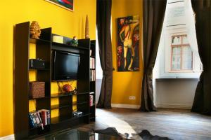 a living room with a tv and a yellow wall at Strumpfeck Suites in Traben-Trarbach
