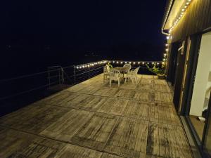 a deck with two chairs and a table at night at Vakantiewoning Verdre met geweldig uitzicht in Saint-Vith