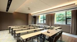 un'aula con tavoli e sedie in una stanza di Echarm Hotel Chengdu Happy Valley Southwest Jiaotong University a Chengdu
