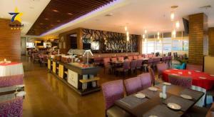 a dining room with tables and chairs in a restaurant at Horison Ultima Semarang in Jomblang