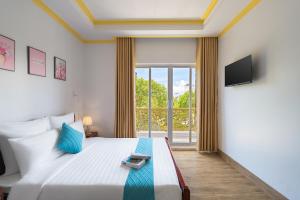 a bedroom with a bed and a large window at Song Ngọc Hotel Phan Thiết in Phan Thiet