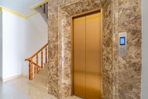 a yellow elevator in a hallway with stairs at Song Ngọc Hotel Phan Thiết in Phan Thiet