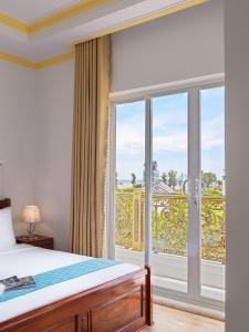 sypialnia z łóżkiem i dużym oknem w obiekcie Song Ngọc Hotel Phan Thiết w mieście Phan Thiet