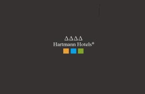 ein Logo für ahakman-Hütten mit Regenbogen in der Unterkunft Chalet Hotel Hartmann - Adults Only in St. Ulrich in Gröden