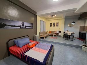 a bedroom with a bed and a living room at The Baluarte in Maasin