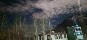 um edifício com uma montanha ao fundo com árvores em Serenity Stay Rangrik em Kaza mais 7 fotografias