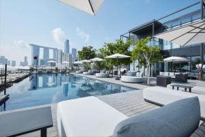 MushayribLuxury Radiant Boulevard Residence的一座大楼的顶部,设有一座带椅子和遮阳伞的游泳池