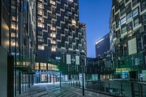 苏州Green Tree Inn Suzhou Wujiang East Tai Lake Tourism Resorts的夜晚城市中的一组高楼