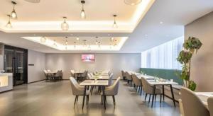 苏州Green Tree Inn Suzhou Wujiang East Tai Lake Tourism Resorts的餐厅里有桌椅的餐厅