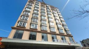 Zhanjiang AirportEcharm Hotel Zhanjiang Zhanchuan Avenue Wanda Plaza的一座高大的建筑,上面有窗户