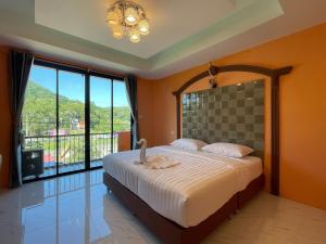 Un dormitorio con una cama grande y una ventana grande en The Morocco, en Kaeng Kachan