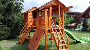 a wooden play house with a slide at Zielony Domek u Gosi Kruklanki in Kruklanki
