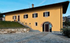 una casa amarilla con una escalera que conduce a ella en Costa di Bussia en Monforte dʼAlba