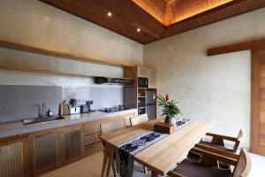 a kitchen with a wooden table and a kitchen counter at Weda Villas in Ubud