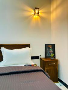 een slaapkamer met een bed en een lamp aan de muur bij Villa Mangrove Serenity in Galle +9 foto's