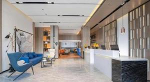 a lobby with blue chairs and a living room at Echarm Hotel Shenzhen International Exhibition Center Fuyong in Fenghuangwei