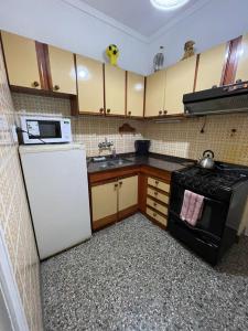una cucina con frigorifero bianco e forno a microonde di 6 personas playa grande con reservación previa a Mar del Plata