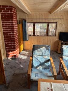 a room with two chairs and a brick wall at Chata v údolí in Rozbehy
