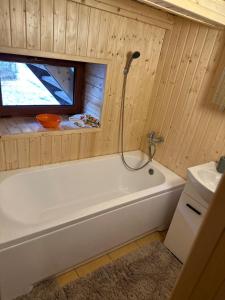 a bathroom with a white tub and a window at Chata v údolí in Rozbehy +11 photos